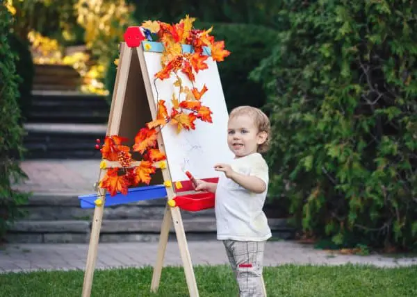 kid drawing with standing easel